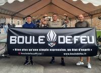 Trois anciens légionnaires à Camerone au GRLE posant derrière la banderole du stand Boule de Feu