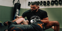 Un sparring intense entre un combattant et Benoit Saint Denis, arborant un t-shirt Boule de Feu, démontrant son état d'esprit combatif et déterminé. Chaque mouvement reflète son engagement absolu et sa volonté inébranlable de surpasser tous les défis