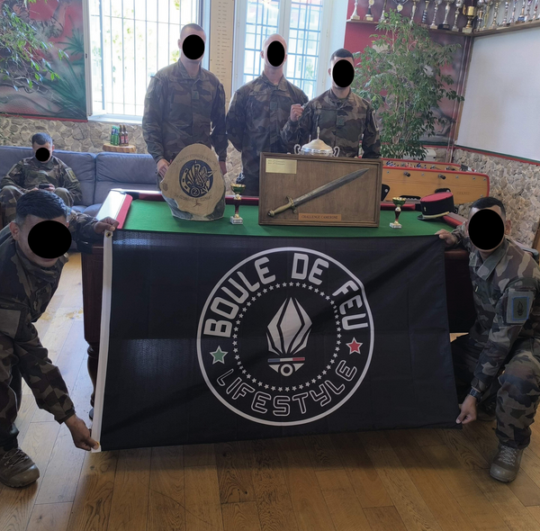 legionnaires du 2e REI posant avec un drapeau Boule de Feu devant des trophées du challenge regimentaire