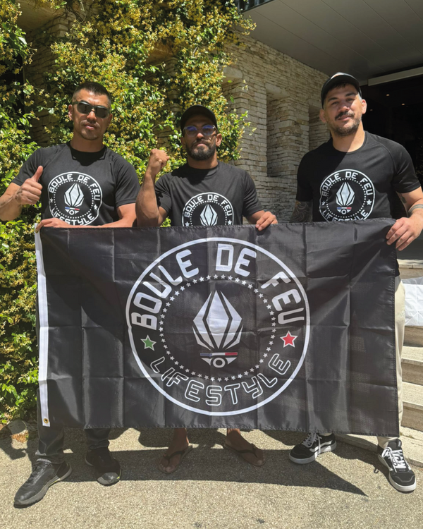 combattants MMA Italo Ribeiro et Gustavo Ataide tenant un drapeau Boule de Feu lifestyle dans une cage d’octogone