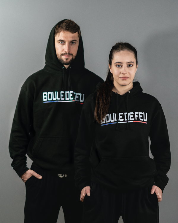 Homme et femme portant le sweat à capuche Impact Boule de Feu noir en coton, hoodie sport lifestyle unisexe