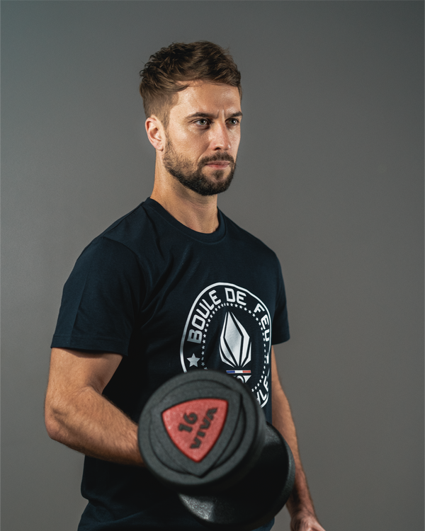 Homme portant le t-shirt Emblem Boule de Feu bleu marine French Navy en coton biologique avec haltère vue de côté