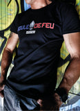 Homme portant le t-shirt Frenchy Boule de Feu noir en coton biologique avec logo bleu blanc rouge devant un mur de graffitis